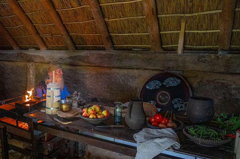 Rustic kitchen counter with food and cooking fire.