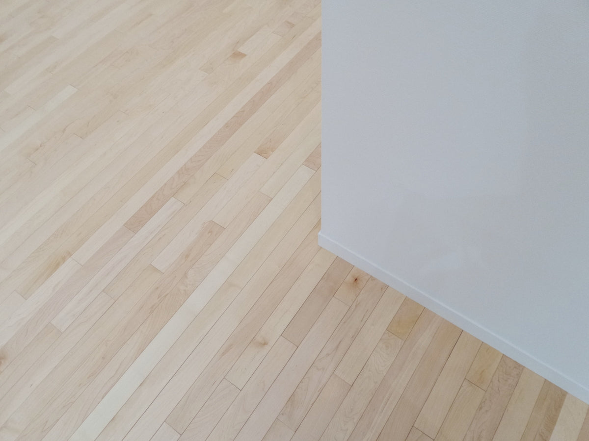 an empty room with hard wood floors and white walls