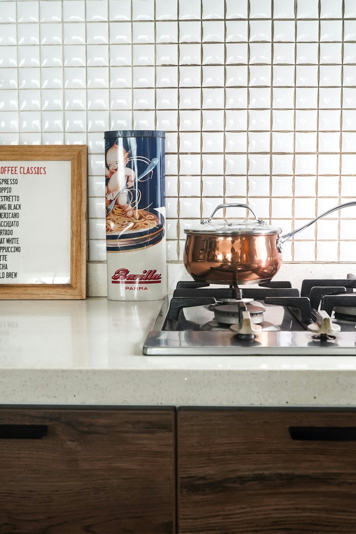 A copper pot sits on the stovetop in a kitchen.