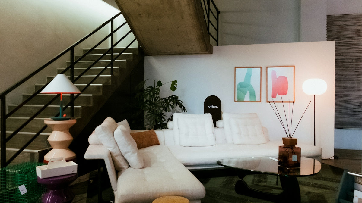 Modern living room with white sofa and stairs.